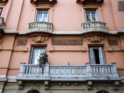 Al di sopra si innalzano quattro piani sui quali notiamo una serie di balconi e finestre con timpani e decori vegetali